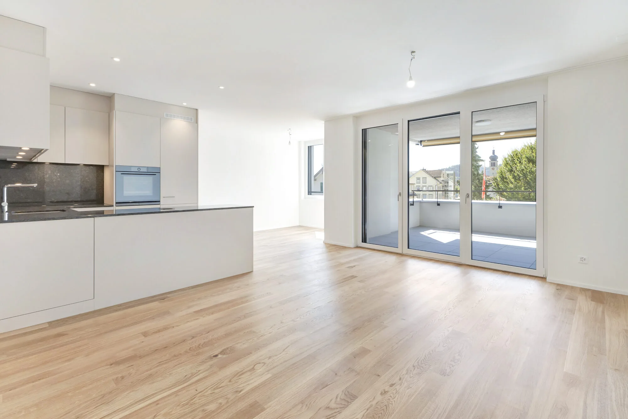 Helliges Wohnzimmer mit moderner Einbauküche und Balkon
