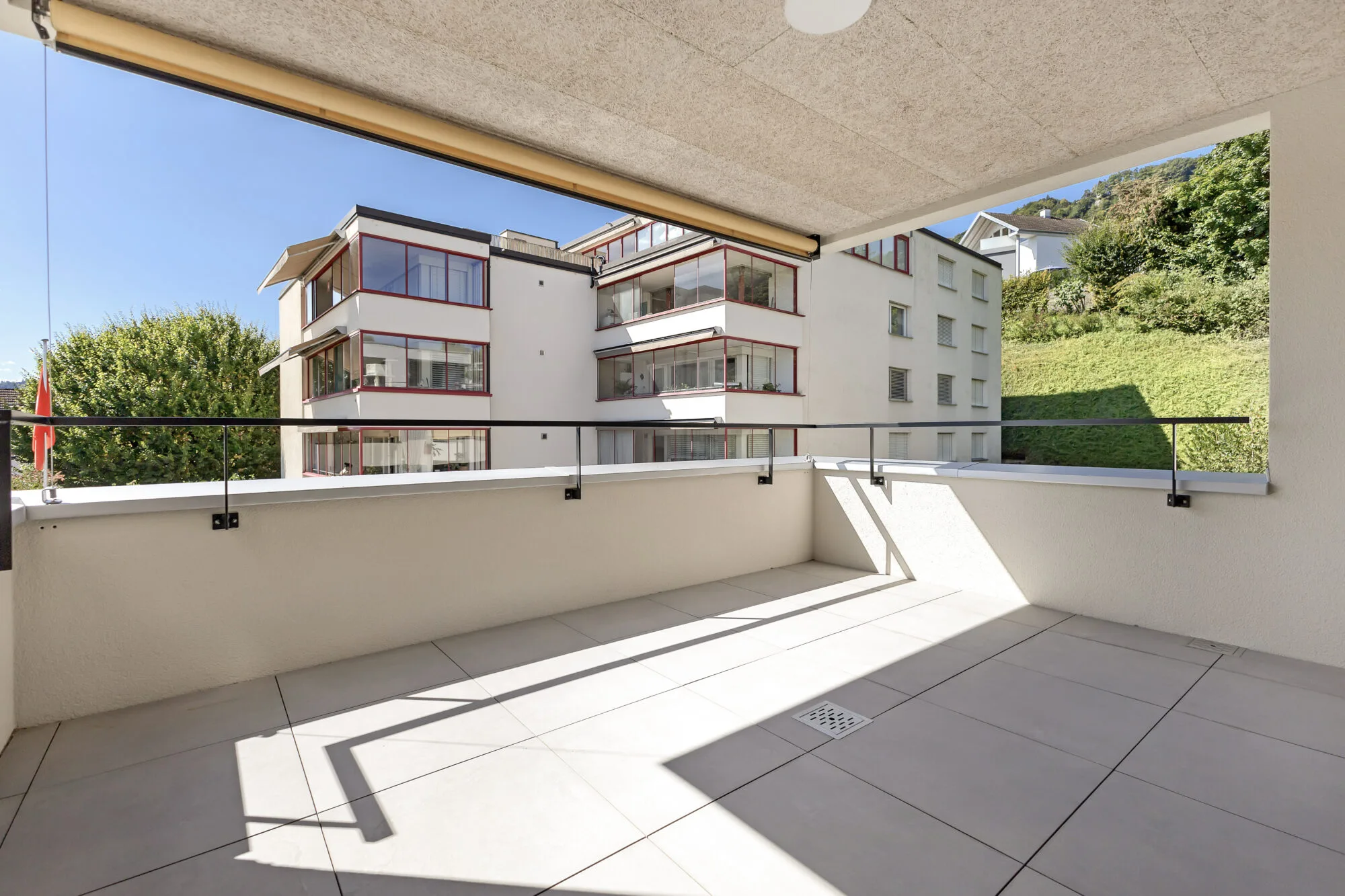 Balkonblick auf moderne Wohnhäuser und Grünfläche