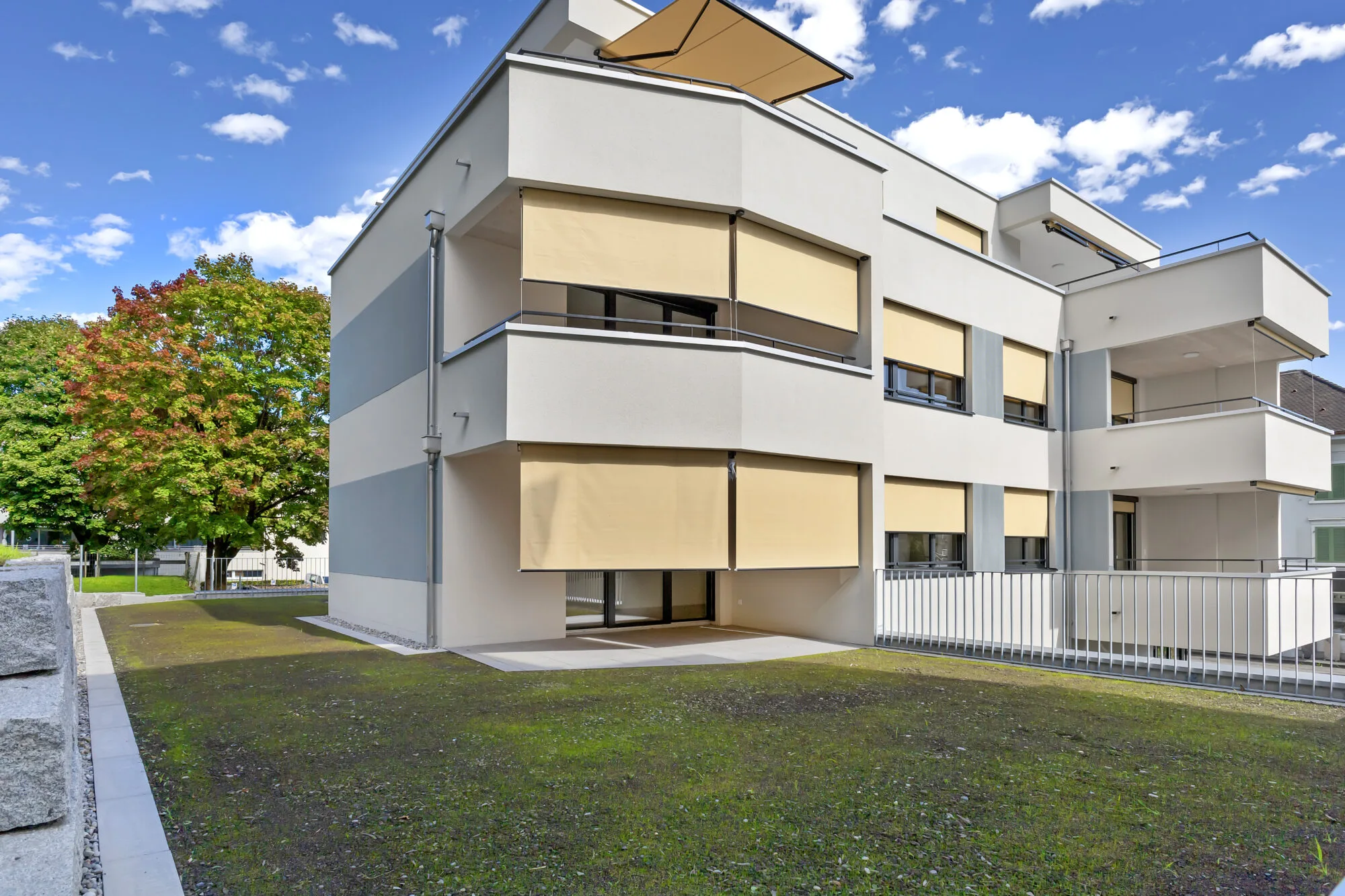 Modernes Wohngebäude mit Balkonen und Sonnenschutz