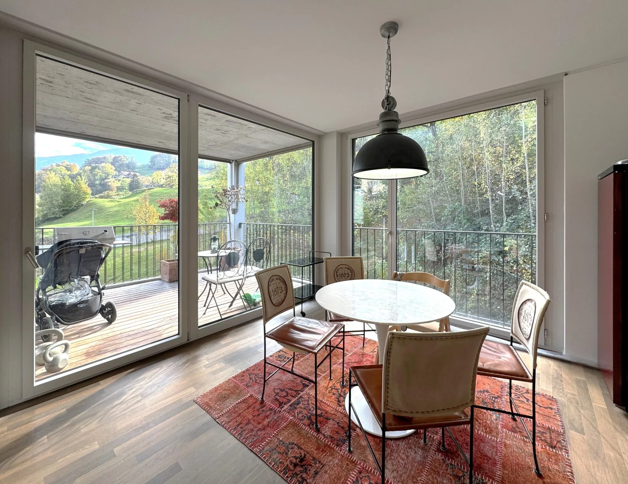 Esszimmer mit Balkonblick auf grüne Landschaft