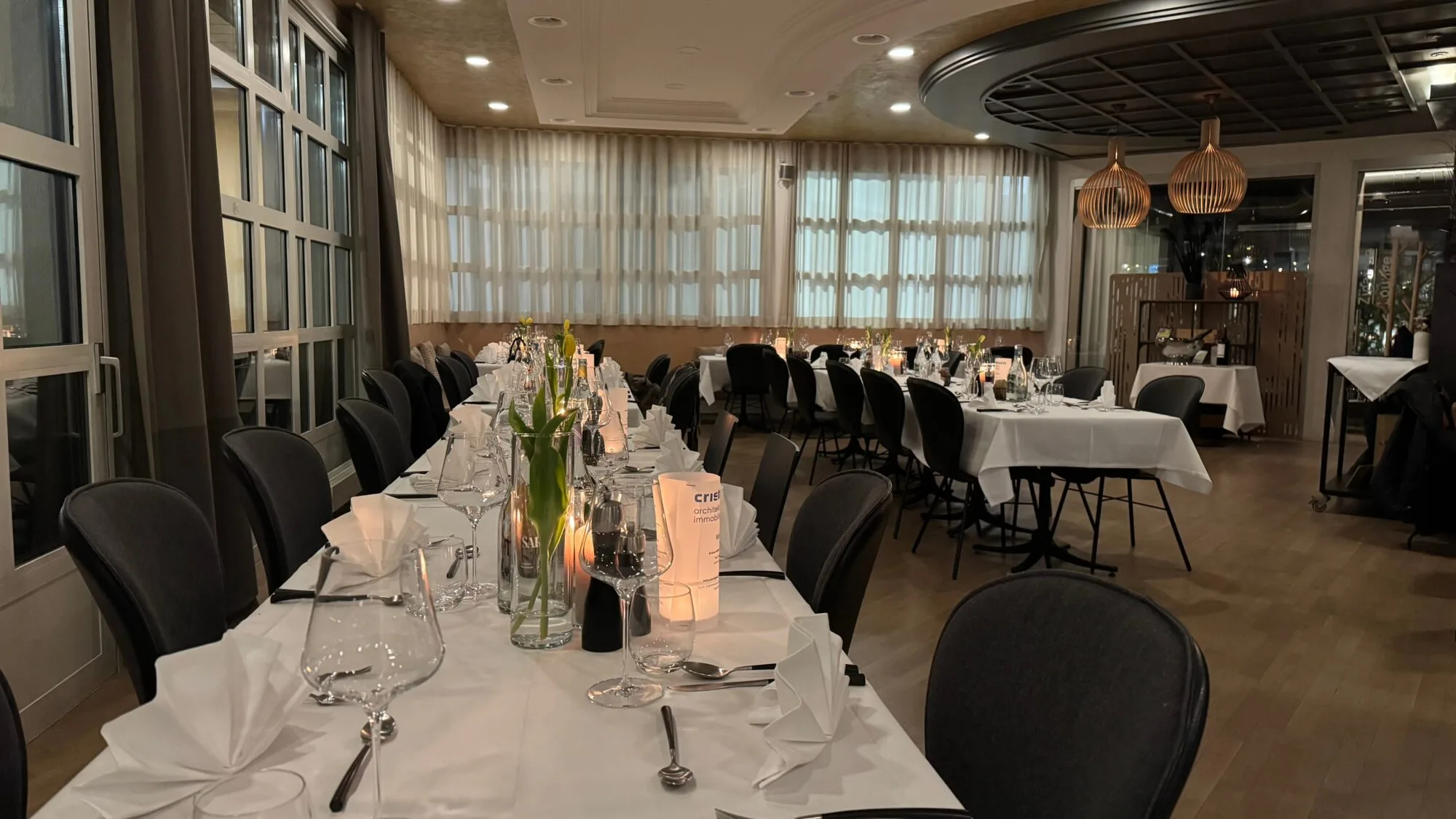 Elegantes Restaurant mit gedeckten Tischen und Kerzenlicht.