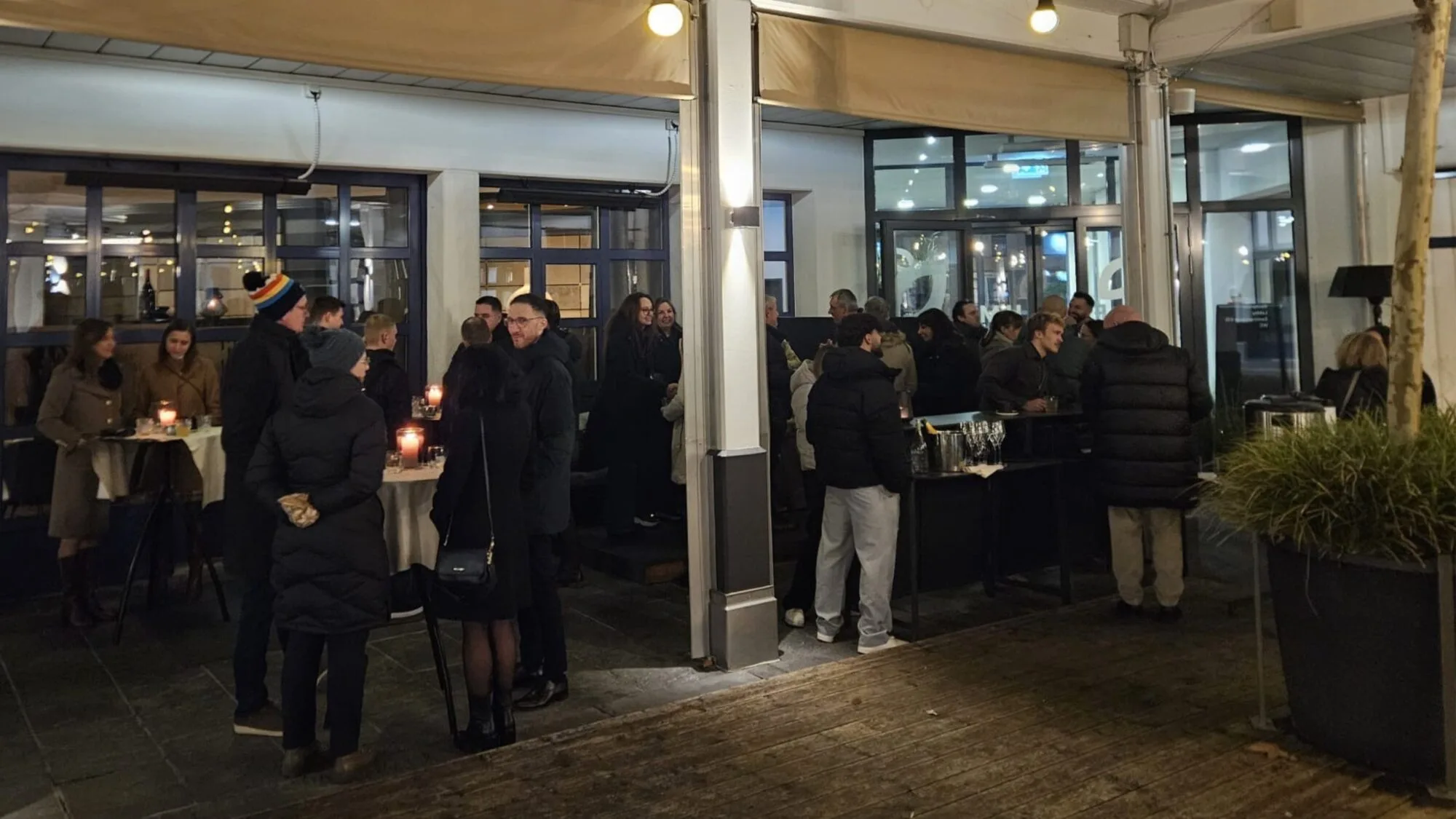 Gruppe von Menschen bei einem Abendempfang im Freien.